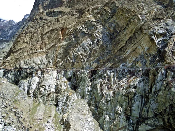 mountain cliff and channel walk at the edge of prestine Hunza Valley, Karakoram Highway, Pakistan