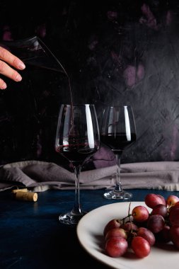 Dekantörden şarap bardağına kırmızı şarap dökmek.