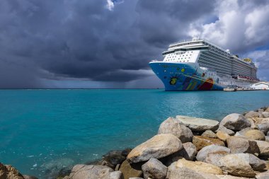 Oranjestad, Aruba: November 5, 2018: A Colorful Cruise Ship Called Norwegian Breakaway, NCL, Docked at Oranjestad Harbor clipart