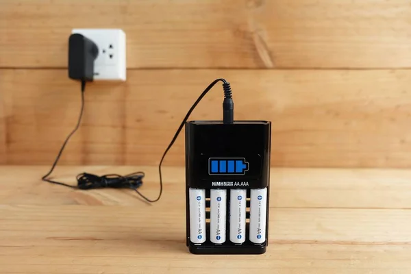 Battery Charger with battery size AA rechargeable On wooden table