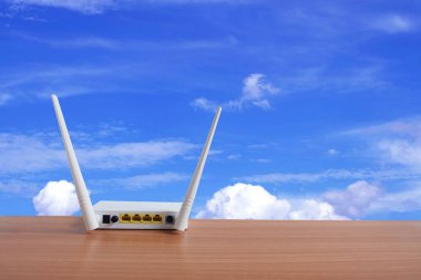 Modem yönlendirici wifi kablosuz mavi gökyüzü ve bulutlar arka plan ile ahşap zemin üzerinde