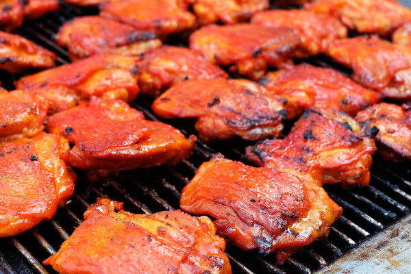 Grilled chicken pieces on the grill.
