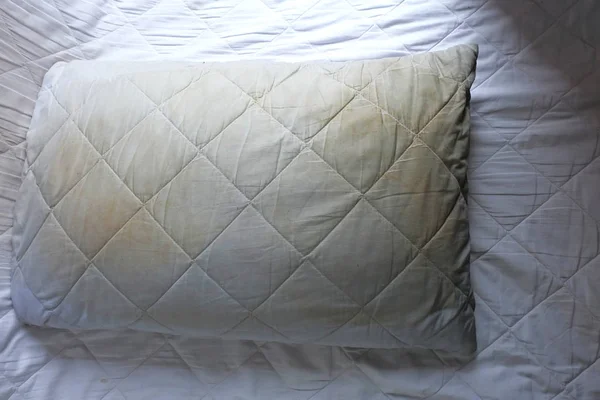 Kirli yastık üzerinde beyaz yatakta