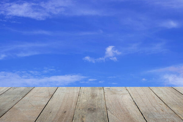Old wooden foreground with blue sky and clouds background, empty space Place a product. Nature and health concept