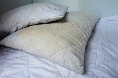 Kirli yastık üzerinde beyaz yatakta