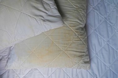 Kirli yastık üzerinde beyaz yatakta
