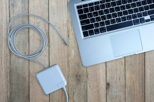 Adapter power cord charger of laptop computer on wood background, Top view