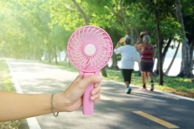 Pembe taşınabilir fan genel parkta yaz aylarında, hava sıcak tutan el