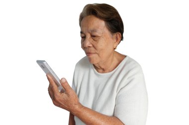 Yaşlı Asyalı kadın beyaz arka plan üzerinde izole bir gülümseme ile cep telefonu kullanarak