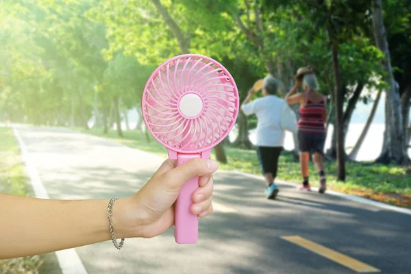 Kezében Rózsaszín Hordozható Ventilátor Nyilvános Parkban Nyári Meleg Időjárás — Stock Fotó