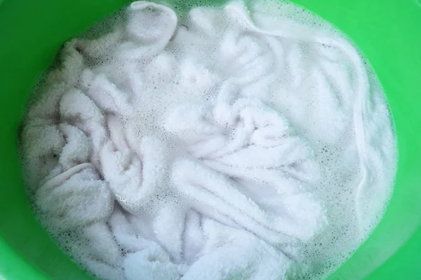 White towel clothes with detergent in basin