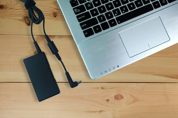 Adapter power cord charger of laptop computer On wooden floor,Top view