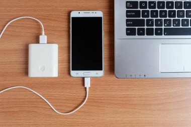 Tapa içinde Usb şarj powerbank giriş cep telefonu veya cep telefonu ve dizüstü bilgisayar ahşap zemin, üstten görünüm üzerinde