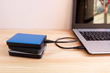Birçok renkli taşınabilir harici sabit sürücüler Usb3.0 bağlanmak için dizüstü bilgisayar ahşap arka plan üzerinde