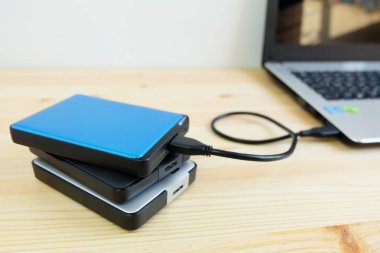 Birçok renkli taşınabilir harici sabit sürücüler Usb3.0 bağlanmak için dizüstü bilgisayar ahşap arka plan üzerinde