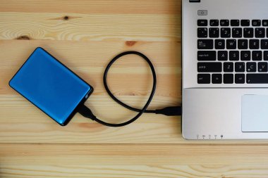 Taşınabilir harici sabit sürücü Usb3.0 bağlanmak için dizüstü bilgisayar ahşap arka plan üzerinde