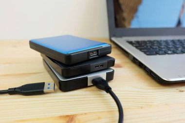 Birçok renkli taşınabilir harici sabit sürücüler Usb3.0 bağlanmak için dizüstü bilgisayar ahşap arka plan üzerinde