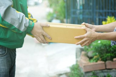 Teslimat adam personel renkli ceket üniformalı hakkında arka plan bulanık ile müşteriye teslim edilecek parsel kutusu tutar