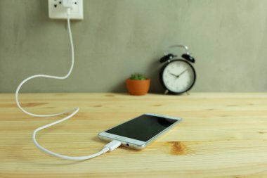 Güç çıkışı adaptör kablosu şarj ahşap zemin üzerinde cep telefonu takın