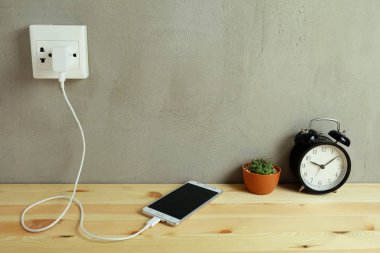Güç çıkışı adaptör kablosu şarj ahşap zemin üzerinde cep telefonu takın