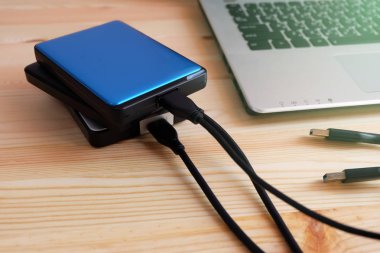 Birçok renkli taşınabilir harici sabit sürücüler Usb3.0 bağlanmak için dizüstü bilgisayar ahşap arka plan üzerinde
