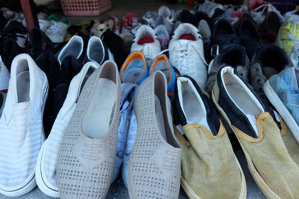 许多旧鞋堆放在二手鞋店 — 图库照片