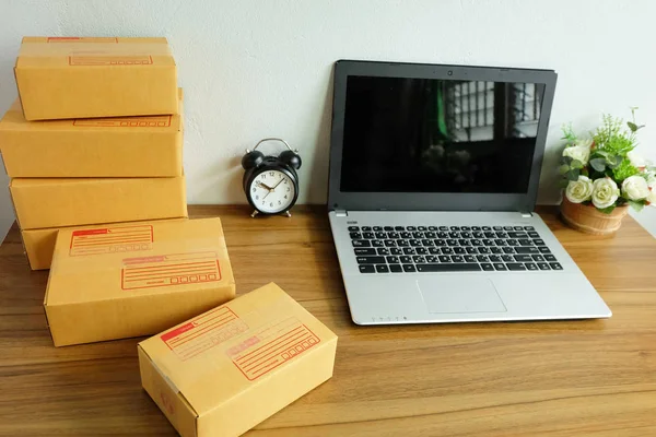 Laptop computer and Product Box or shipping parcel box on wooden table, Online shopping, work at home, e commerce