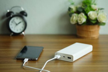 Akıllı telefon masaahşap masada yedek pil veya Power bank ile şarj