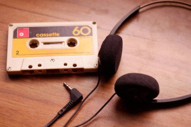 Ahşap arka planda antika kaset ve Retro kulaklık, 70-80-90 'lar için cihazlar.