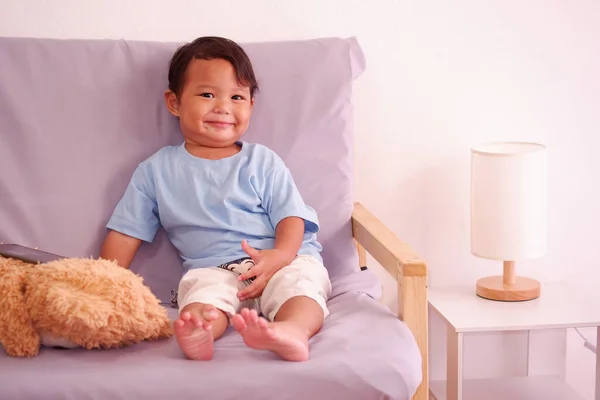 Słodkie Azji Chłopiec Lat Uśmiechając Się Kanapie Salonie — Zdjęcie stockowe