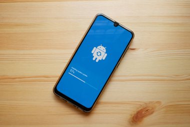 Bangkok, Tayland - 1 Ekim 2020 Smartphone ekranı ahşap arka planda android sistemine güncelleniyor..