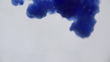 Su mavi mürekkeple. Renkli mavi boya yumuşak su altında dönen suya karıştırma yukarıda bırakır. Ağır çekim. 