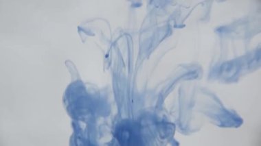 Su mavi mürekkeple. Renkli mavi boya yumuşak su altında dönen suya karıştırma yukarıda bırakır. Ağır çekim. 