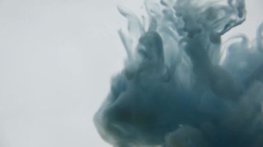 Mavi ve yeşil mürekkep su. Renkli mavi ve yeşil boya yumuşak su altında dönen suya karıştırma yukarıda bırakır. Ağır çekim. 