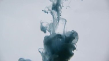 Mavi ve yeşil mürekkep su. Renkli mavi ve yeşil boya yumuşak su altında dönen suya karıştırma yukarıda bırakır. Ağır çekim. 