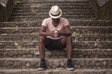 Hayat hakkında eski bir kasaba düşünme sokaklarında bir merdiven üzerinde oturan bir siyah adam çekim manzara