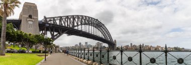 Sydney Harbor, Avustralya - 23 Ekim 2018 Sydney Liman Köprüsü. Arabalar onun yanına park edilmiş ve turistler altında yürüyorlar..