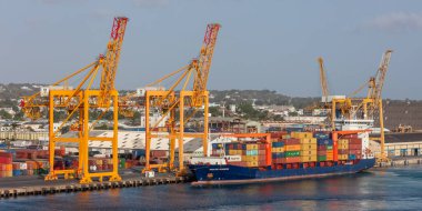 Bridgetown limanı, Barbados, Batı Hint Adaları - 16 Mayıs 2020: Vinçlerin yüklendiği Bridgetown limanı ve konteynırlarla yüklü kargo gemisi