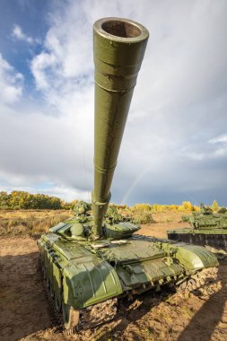 Sahada Rus tankı T-64 'ün yüksek açılı görüntüsü. Top doğrudan kameraya doğrultuluyor. Arkaplan olarak mavi bulutlu gökyüzü.