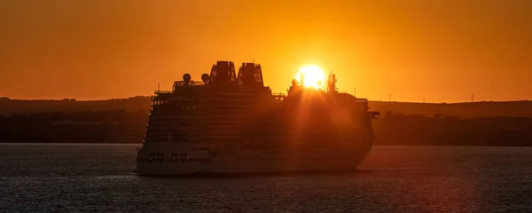 英国のウェイマス湾 2020年7月10日 日没時にウェイマス湾に停泊するP Oクルーズ船ブリタニアの素晴らしいパノラマショット その上にオレンジの色をキャスト船の真上に沈む太陽 — ストック写真
