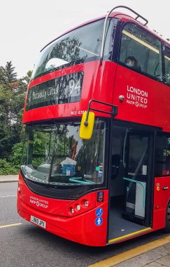 Londra, İngiltere - 8 Temmuz 2020: Modern kırmızı çift katlı otobüs Londra şehir merkezinde insanları bekliyor. Üzerinde Piccadilly Sirki 94 yazıyor. İkinci güvertede oturan ve maske takan biri..
