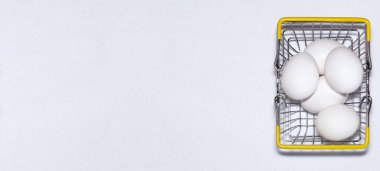 Alışveriş arabasında taze yumurta. Alışveriş, satın alma ve yemek teslimatı konsepti. Beyaz arka plan. Yakın çekim. İzole edilmiş. Panorama, kopyalama alanı olan pankart boyutu.