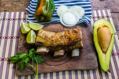 avokado ve sebzeler eşliğinde ön planda lezzetli kaburga eti