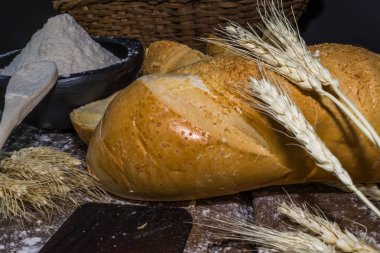 Natürmort sivri ile dekore edilmiş siyah arka plan üzerine ekmek ve buğday unu