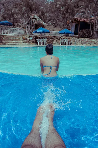 young woman sitting on the edge of the pool