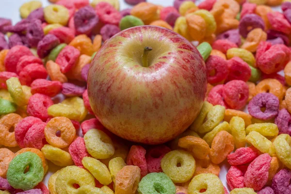 WHOLE APPLE ON COLORFUL CEREAL — Stock Photo, Image