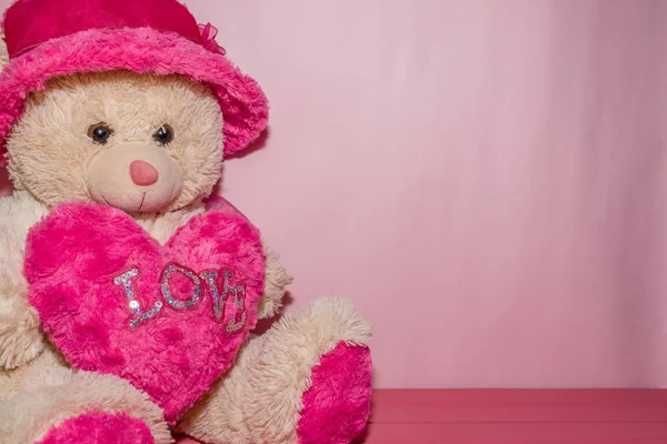 Ursinho segurando coração rosa com a palavra amor — Fotografia de Stock