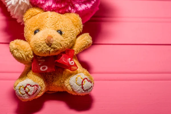Ursinho segurando coração rosa com a palavra amor — Fotografia de Stock