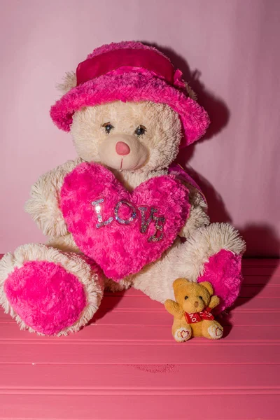 Oso de peluche sosteniendo el corazón rosa con la palabra amor — Foto de Stock