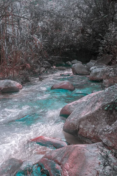 surreal landscape of river with water blue aquamarine and big stones